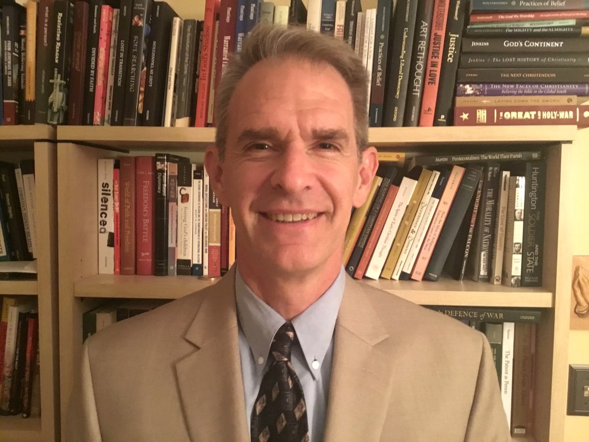 Christopher J. Eberle in front of bookshelves